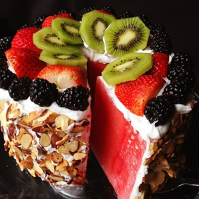 Watermelon Cake! A cake made from watermelon and whipped coconut cream icing, and decorated with toasted sliced almonds and fresh fruit.