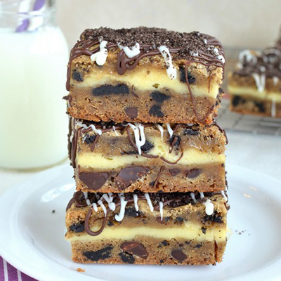 Oreo Chocolate Chip Cheesecake Cookie Bars - cookie dough layered with cheesecake and topped with chocolate.