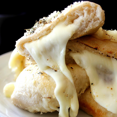 Recipe for Cheesy Biscuit Bombs - Not only do these fluffy, tender cheese filled Biscuits jazz up any meal..they can almost BE the meal! With a long-range Cheese stretch that’s capable of reaching you from miles away, escape is not possible!