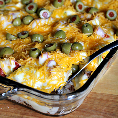 Haystacks ~ Yummy casserole full of rice and taco meat, topped with a cheese sauce, lettuce, tomatoes and olives! 