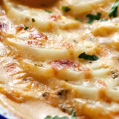 Scalloped Potatoes with Cheddar and Parmesan in Sun Dried Tomato Pesto - These scalloped potatoes are made with broth, not milk, and get extra flavor from sun-dried tomato pesto. They are fabulous with roast chicken.